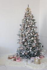 new year and Christmas tree with white and pink toys and gift boxes