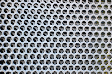 Metal plate with round holes. Honeycombs. Background image or texture of a hole in metal