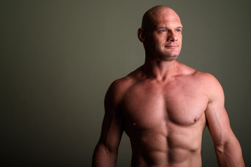 Fototapeta premium Bald muscular man shirtless against colored background