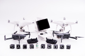 Flying drones lie on a white surface and black dice and inscriptions sale of drones