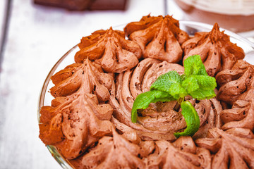 Homemade chocolate mousse in portion glass on wooden background. Close up