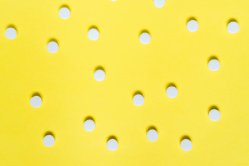 white medicine pills on yellow background. Medical and healthcare concept
