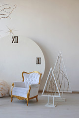  New Year's interior with white walls, wooden stairs, armchair and golden stars