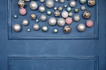 Pink and silver Christmas balls on the background of the dark blue wall. 