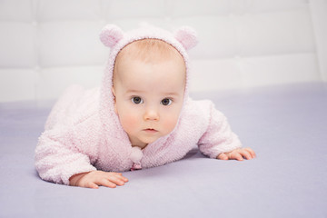 close-up surprised little baby lying on his tummy