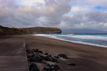 beach with black volcanic sand with turquoise sea water. Seascape in the Portuguese coastline....