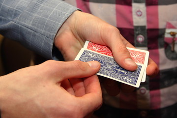 Black card - playing cards with a red and blue shirt in the hands of the illusionist