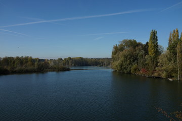 Obraz premium Blick auf einen von Wald umgebenen See mit Holzsteg
