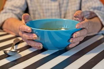 Fototapeta na wymiar elderly woman holding a bowl of soup
