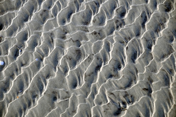 Wellenmuster auf Sandstrand Hintergeund formatfüllend 