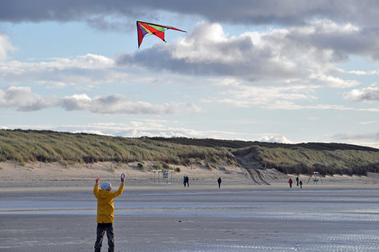 Lenkdrachen fliegen lassen am Strand bei kaltem Wetter
