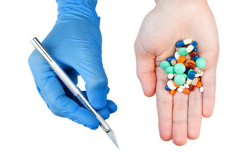 Hands holding tablets and scalpel with blue rubber glove isolated on white. Concept surgery vs...