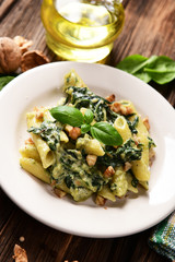 Penne pasta with spinach, gorgonzola cheese and walnuts