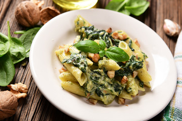 Penne pasta with spinach, gorgonzola cheese and walnuts