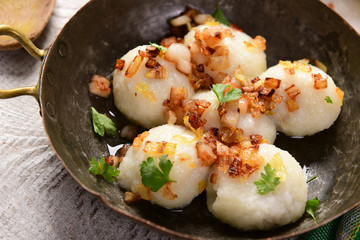 Meat stuffed potato dumplings with fried onion  and greaves on top