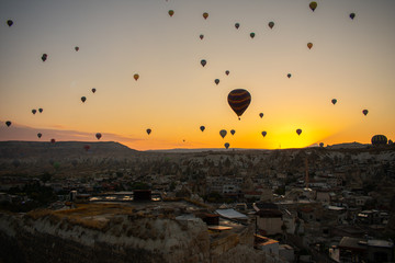 Beautiful sunset over Cappadocia, Goreme. Balloons flying against sky, aerial view. Most popular place in Turkey