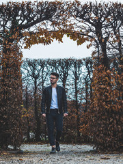 Fototapeta premium young man with glasses walking in park in winter
