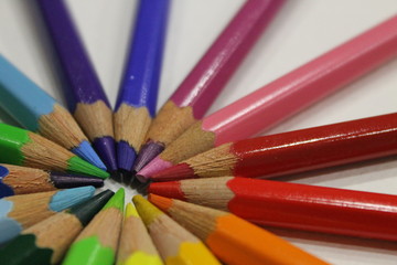 Colored Pencils Lying Around The Heart On A White Background