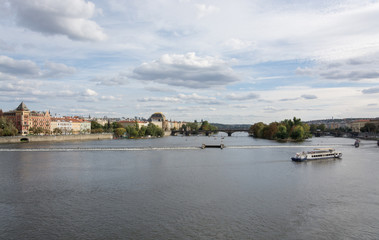 Fototapeta na wymiar Prague waterfront panorama on a cloudy day, with Vltava river, Legion bridge and the National Theater landmarks in sight 