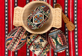 Set of wooden Easter eggs painted in traditional Eastern European style with a floral or geometric design.