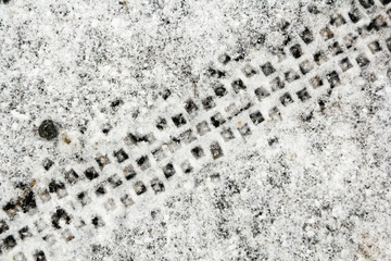 Shoes and bicycle tyre tracks on a snow, abstract background