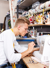 Obraz premium Dressmaker making clothes with sewing machine