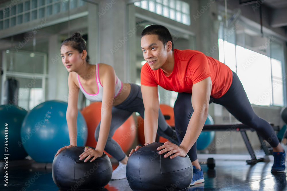 Wall mural attractive sports people are working out with fitness balls in gym