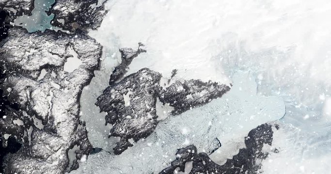 Vertical aerial ascent through heavy falling snow, over Jakobshavn Glacier, Greenland. Elements of this image furnished by NASA. 