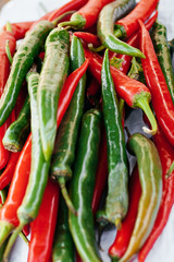 heap of red and green hot chilli peppers close up. color contrast