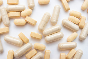 Medicine yellow pills or capsules on a white background close-up. vitamins Drug prescription of drugs for treatment. Pharmaceutical drug, cured in a container for health. Antibiotic drugs.