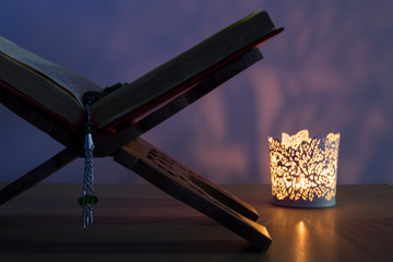 Quran and rosary beads on the white background with light lantern or candle for Islamic concept. Holy book Koran for Muslims holiday, Ramadan,blessed Friday message and three months