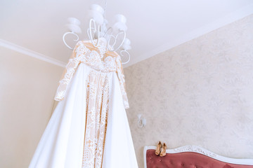 beautiful wedding dress hanging on a chandelier in the bedroom