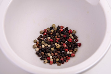 white mortar with coloured peppercorns