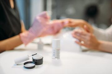 Open bottle with white nail polish and brush