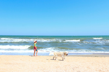 Summer Holiday, Travel, Happiness, Pets Concept. Young Girl Playing With A Dog On The Beach.Young Little Girl And Golden Retriever Dog Running On The Beach. Dog And Owner Outdoors.
