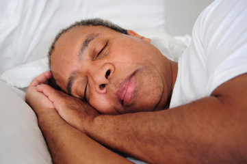 Fototapeta na wymiar African american male relaxing in bed at home.