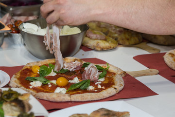 Pizza Maker who Prepares a Delicious Pizza with Bacon and Cherry Tomatoes