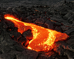 Hot magma escapes from an earth crevice as part of an active lava flow, the glowing lava slowly cools and freezes - Location: Hawaii, Big Island, volcano "Kilauea"