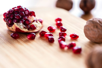 The piece of pomegranate and with fruits on the wooden plate