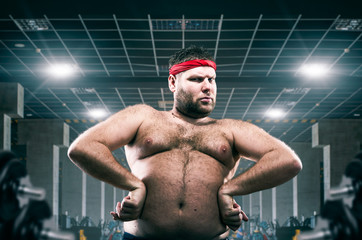 Fat athlete on workout in fitness club, fatness