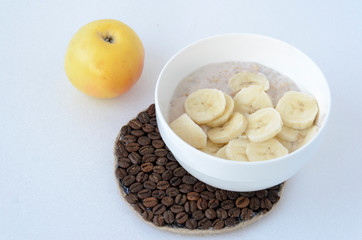 Breakfast still life with oatmeal porridge, fruits and coffee cup, top view, selective focus, shallow depth of field.