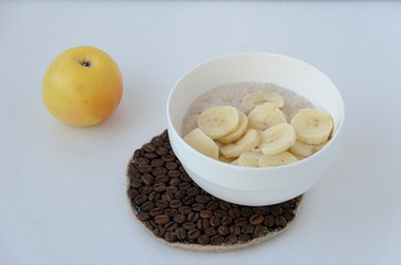 Breakfast still life with oatmeal porridge, fruits and coffee cup, top view, selective focus, shallow depth of field.