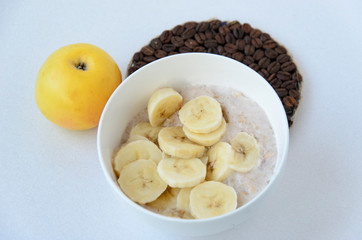 Breakfast still life with oatmeal porridge, fruits and coffee cup, top view, selective focus, shallow depth of field.