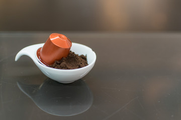 Coffee capsule for a coffee machine with ground coffee in a white bowl