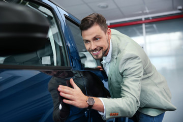 Fototapeta na wymiar Man near new car in modern auto dealership