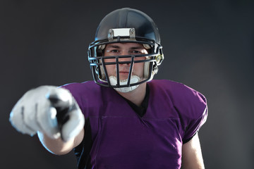 American football player wearing uniform on dark background