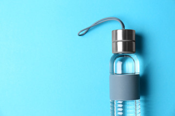 Sport bottle with space for text on color background, top view