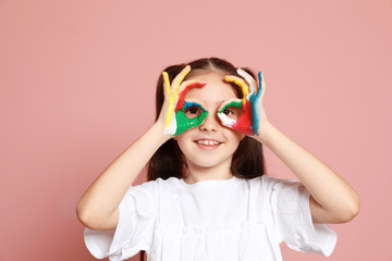 Little child with painted hands on color background
