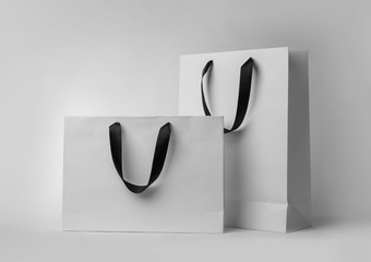 Paper shopping bags with ribbon handles on white background. Mockup for design - Powered by Adobe