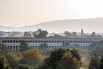 The Stoa of Attalos, a recreation of a stoa that once stood in the Ancient Agora of Athens, Greece, at sunrise, with trees turning for autumn.